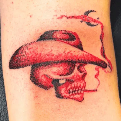 Red cowboy skull tattoo created using pointillism dotwork technique